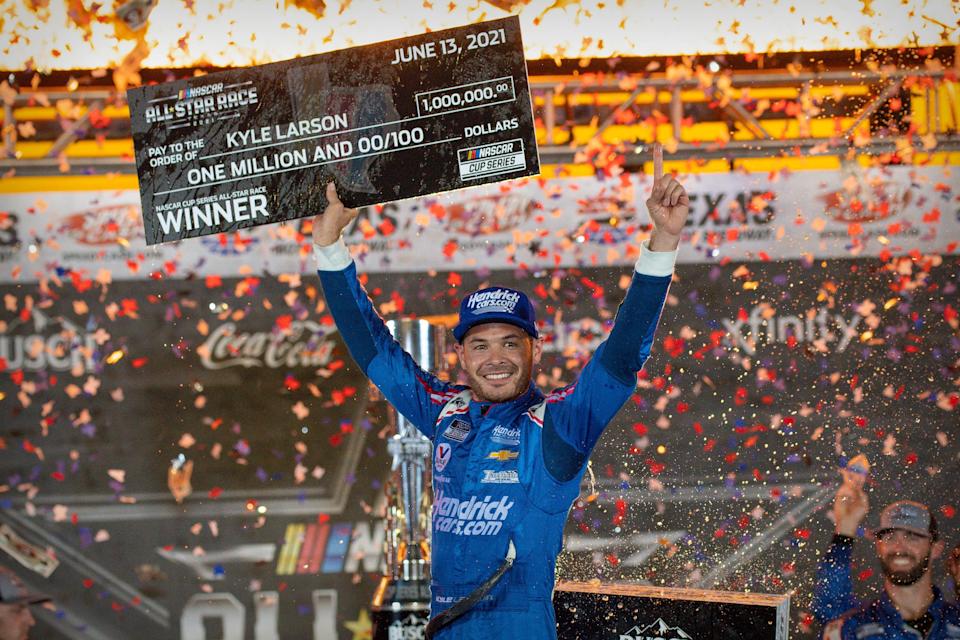 Kyle Larson holds up a $1 million check after winning the 2021 NASCAR All-Star Race at Texas Motor Speedway.