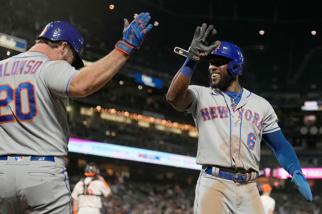 Starling Marte high-fives Pete Alonso after scoring one of the runs on Francisco Lindor's three-run triple during the Mets loss.