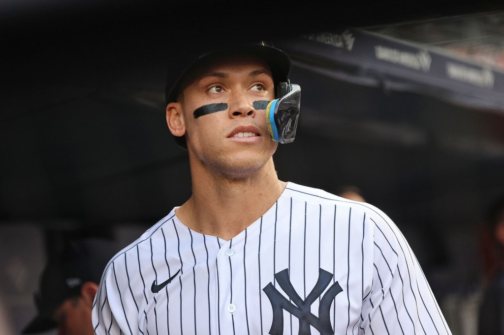 New York Yankees center fielder Aaron Judge #99 is greeted by his teammates in the dugout