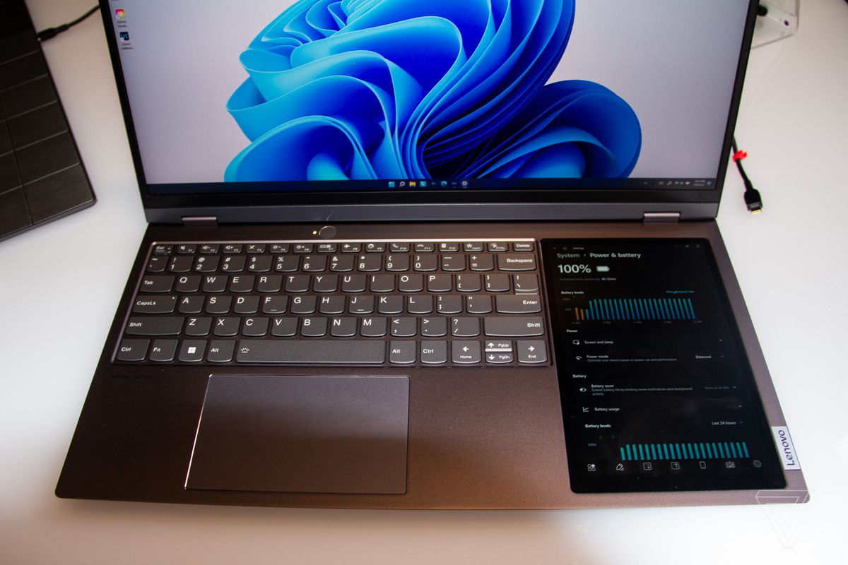 The Lenovo ThinkBook plus Gen 3 keyboard seen from above.  The primary screen shows a blue swirl on a white background.