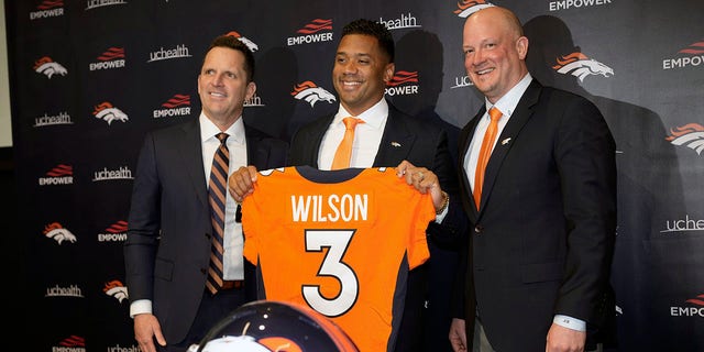 Denver Broncos new quarterback Russell Wilson, center, is flanked by head coach Nathaniel Hackett, right, and general manager George Paton after a news conference Wednesday, March 16, 2022 at team headquarters in Englewood, Colo. 