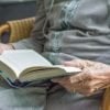 This shows an elderly lady reading a book