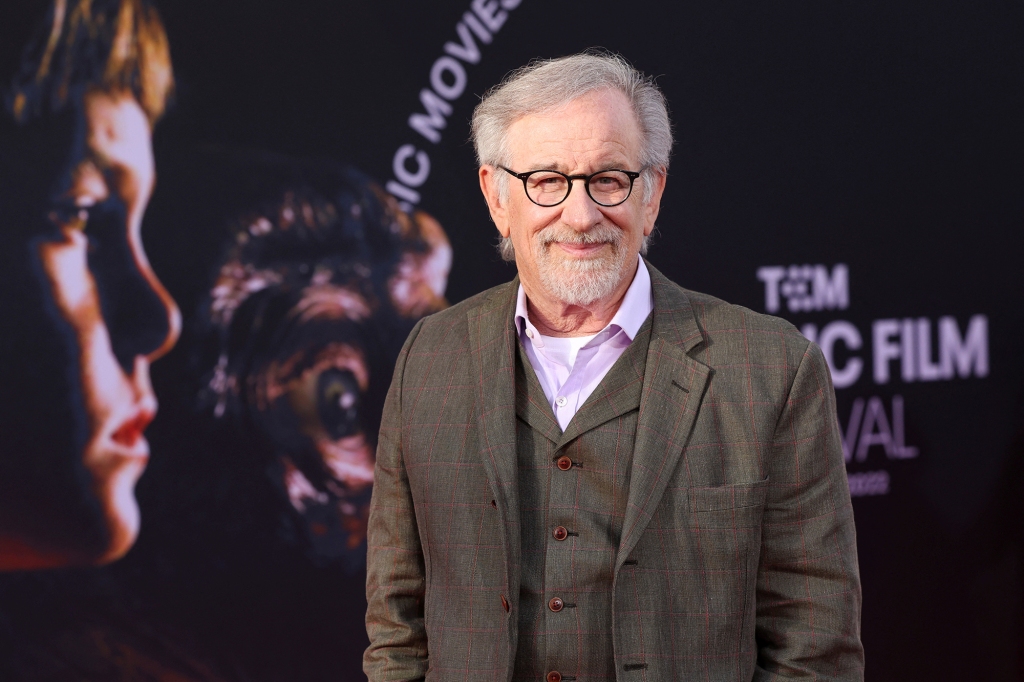Steven Spielberg in front of an ET poster.
