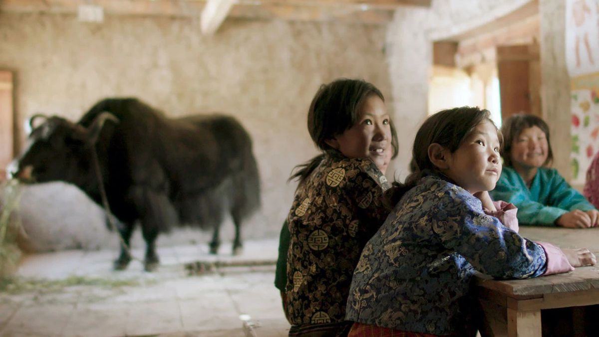 Children in a classroom with a yak in the background.