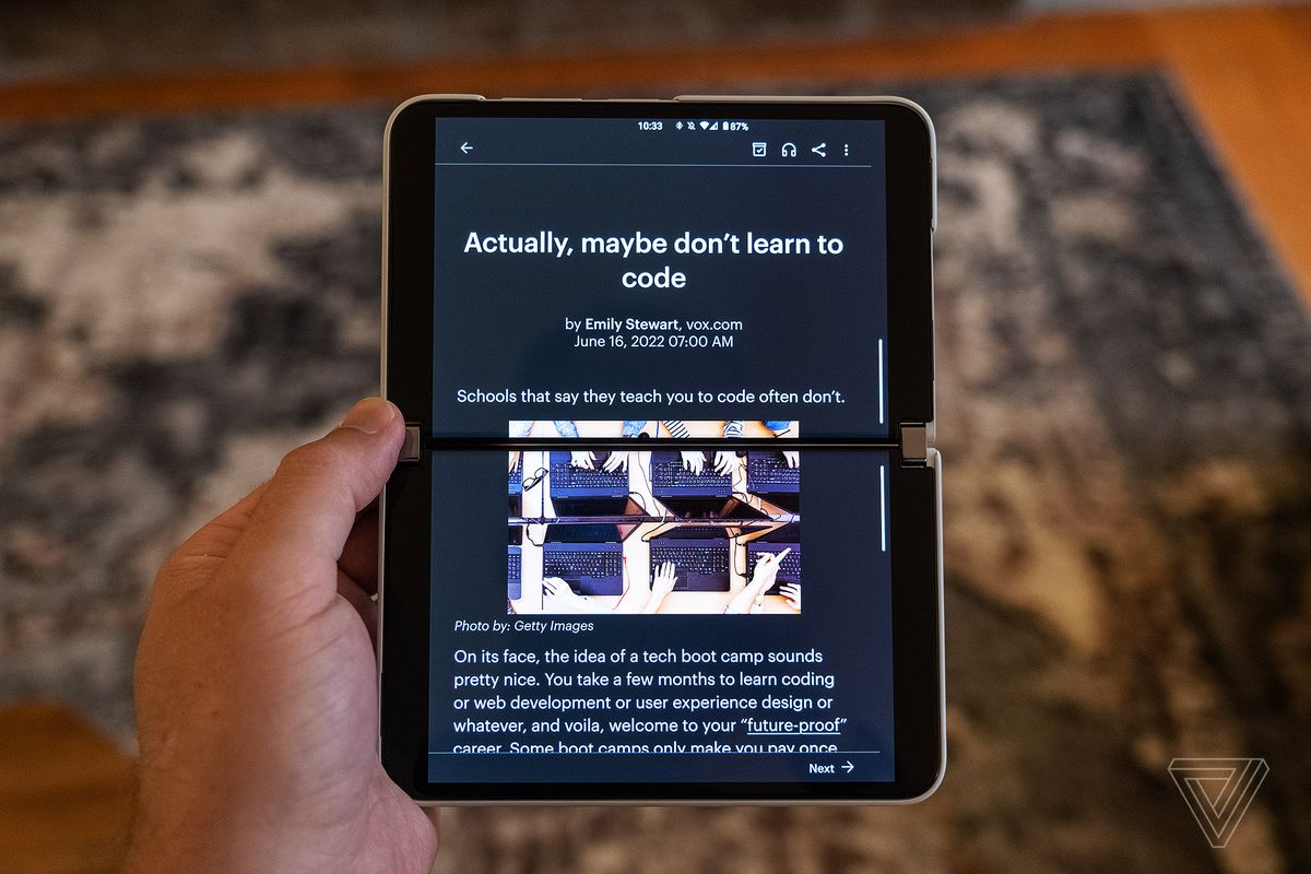 The Pocket Android app displays an article on both screens of the Surface Duo 2 while holding it in portrait mode.