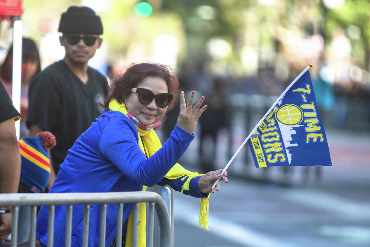 A woman holds up four fingers for the four champions of the Golden State Warriors before the Golden State Warriors Championship parade on Market Street in San Francisco, California June 20, 2022.