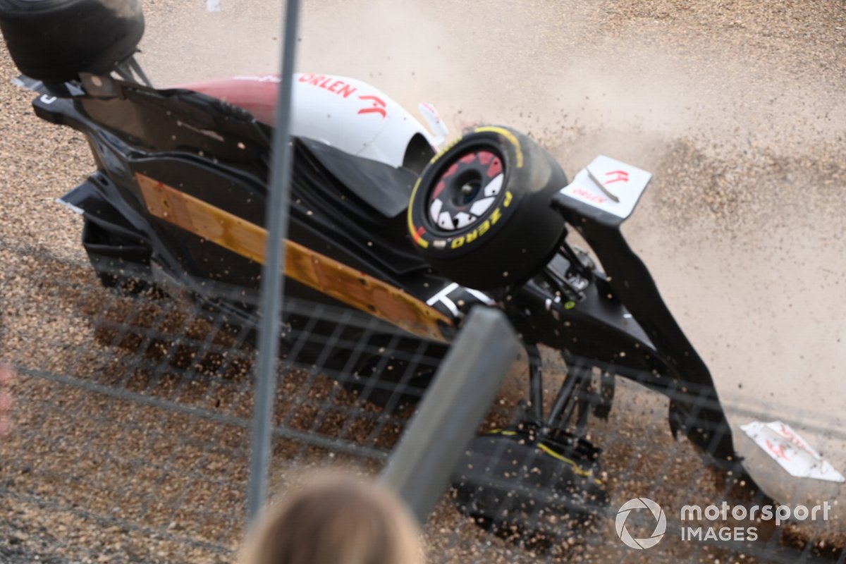 Zhou Guanyu, Alfa Romeo C42, slides headfirst over the gravel after falling at the start