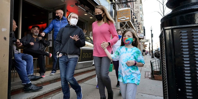 People walking down the street wear masks against COVID-19.